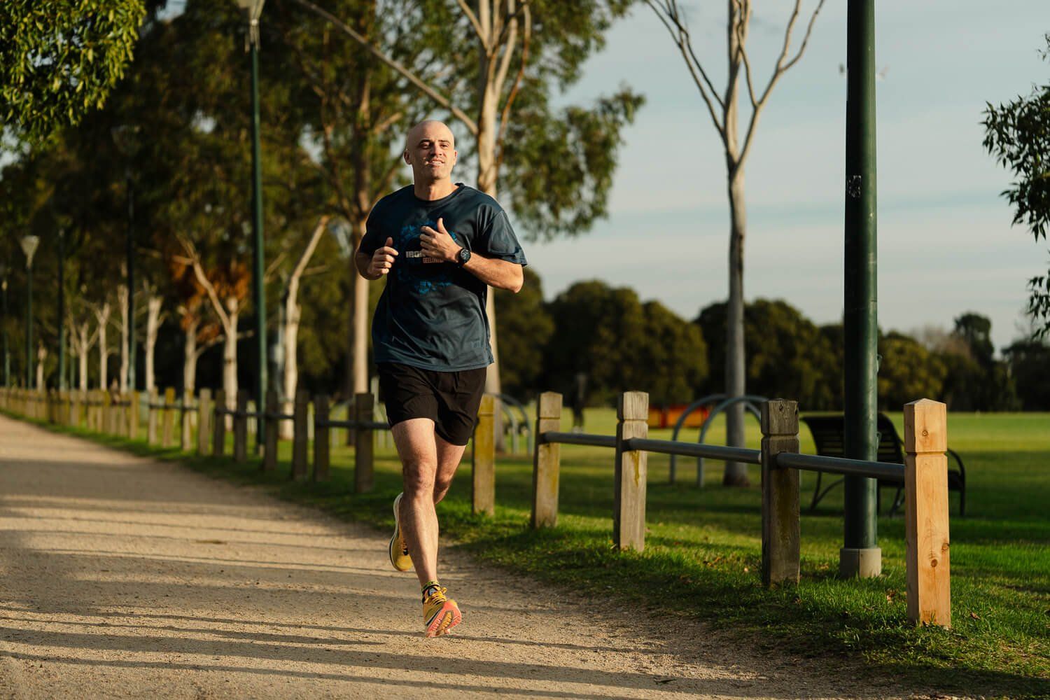 Dan running along a gravel path beside a timber fence